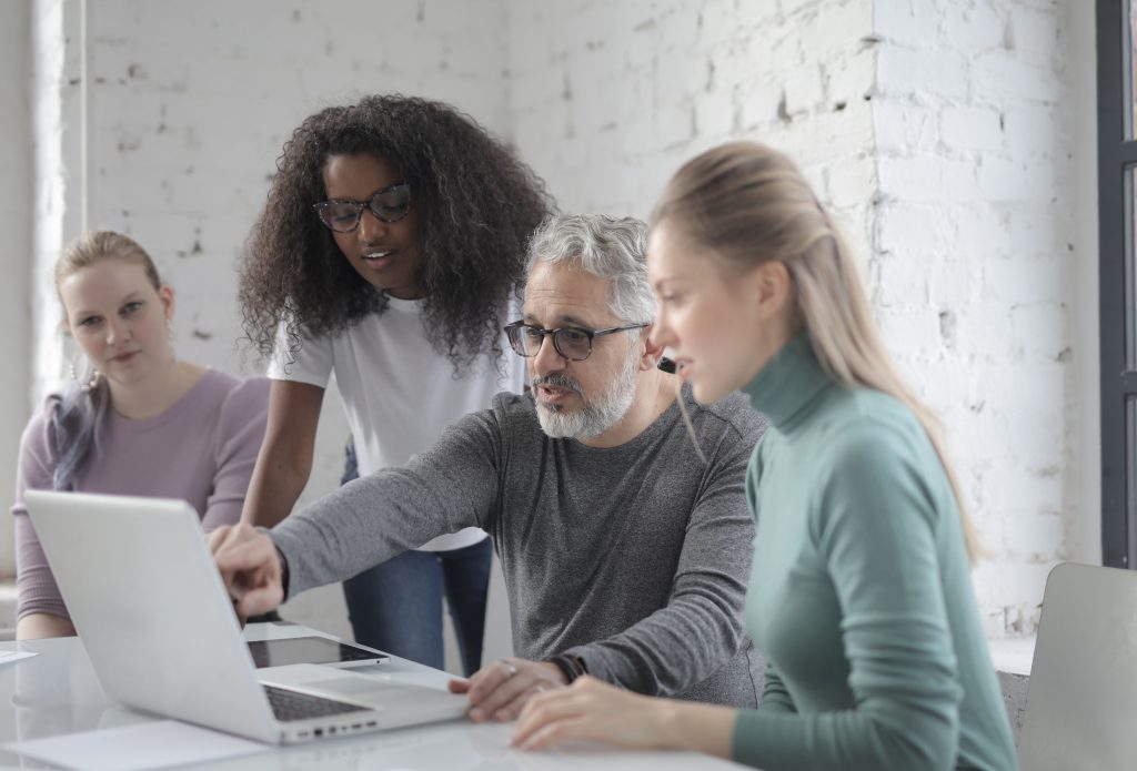 Team members reviewing work together on a laptop